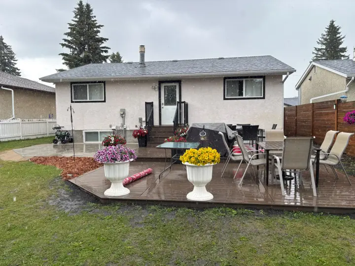 Two-tier composite deck and stone patio in a Red Deer back yard, built by Green Ladder Contractors