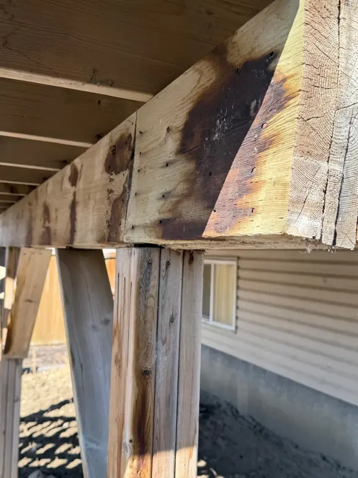 Water staining and rot tracking along a deck support beam in Red Deer, Alberta