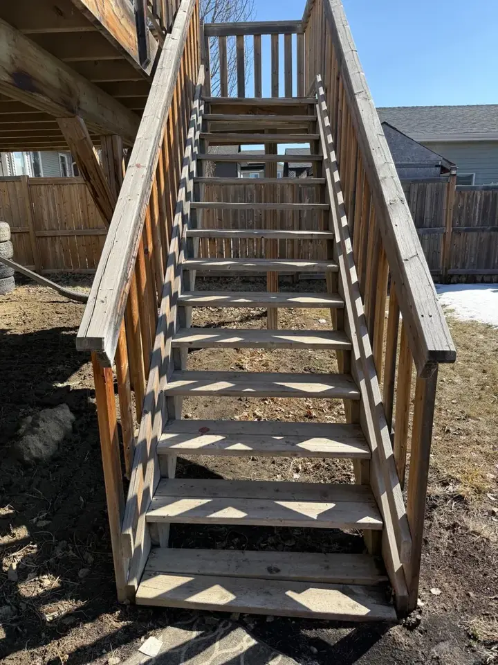 Weathered pressure treated deck staircase awaiting repair assessment in Red Deer, Alberta