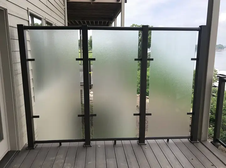 Frosted tempered glass privacy panels in a black aluminum frame on a deck