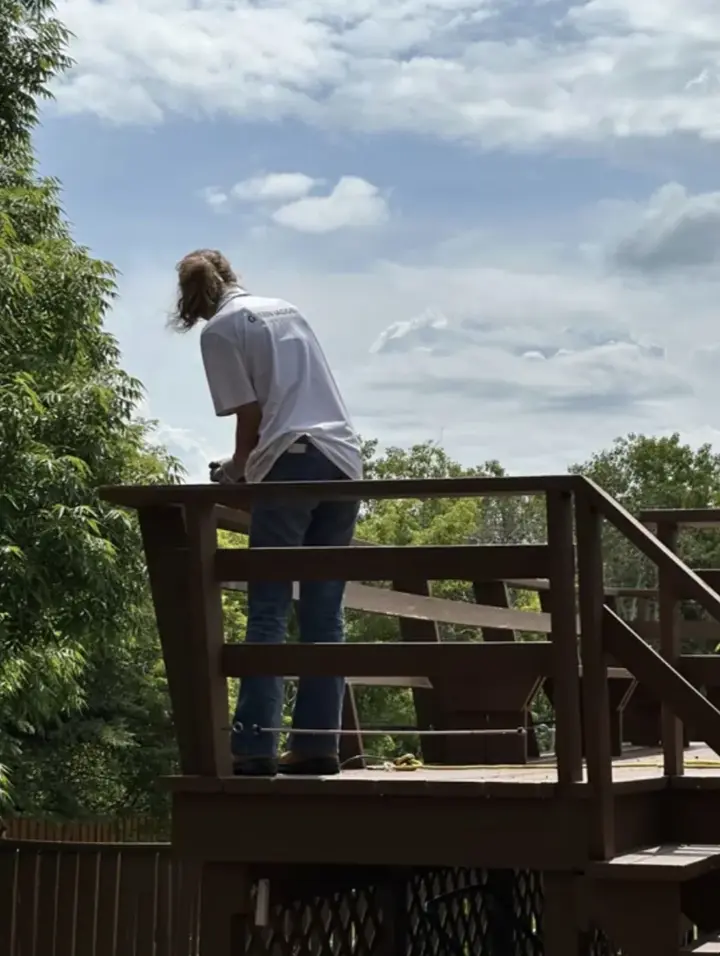 Green Ladder Contractors crew member repairing deck railing in Central Alberta