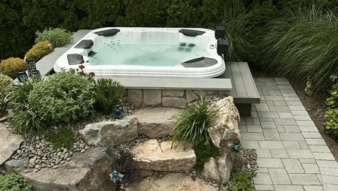 Hot tub set into a deck surround with steps and railing
