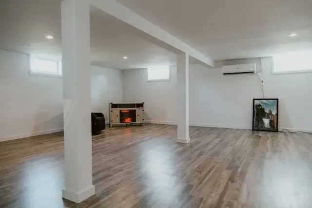 Finished 857 square foot basement development with pot lights and laminate flooring in Red Deer, AB - built by Green Ladder Contractors