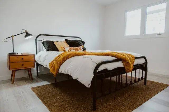 Refreshed primary bedroom with new laminate flooring, lighting and trim in Red Deer, AB - renovated by Green Ladder Contractors