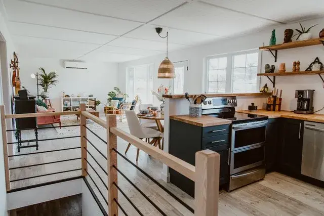 Renovated kitchen with navy cabinetry, butcher block counters, and stainless appliances
