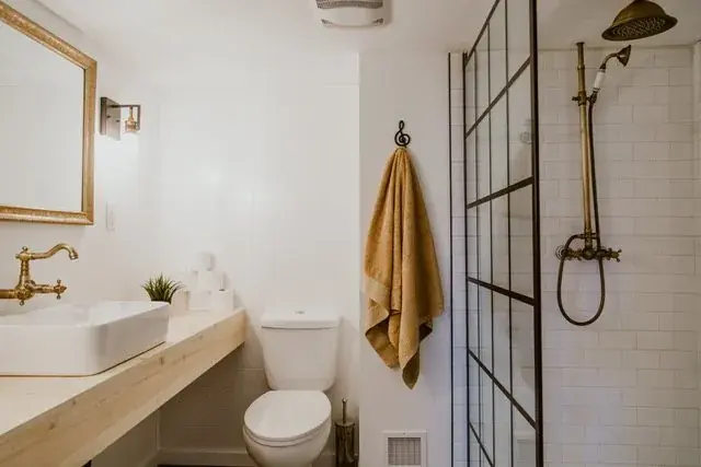 Gutted downstairs bathroom with tiled shower, antique brass rain shower and custom raw pine floating vanity in Red Deer, AB - built by Green Ladder Contractors