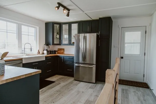 Renovated Red Deer kitchen with navy cabinetry, butcher block counters, and stainless appliances