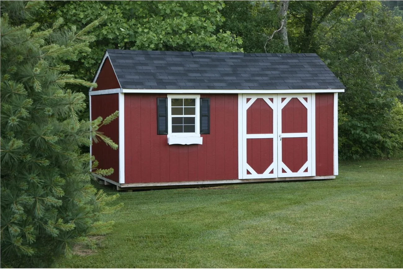 Long red board and batten storage shed with white trim, black shutters, double doors, and a dark shingled roof